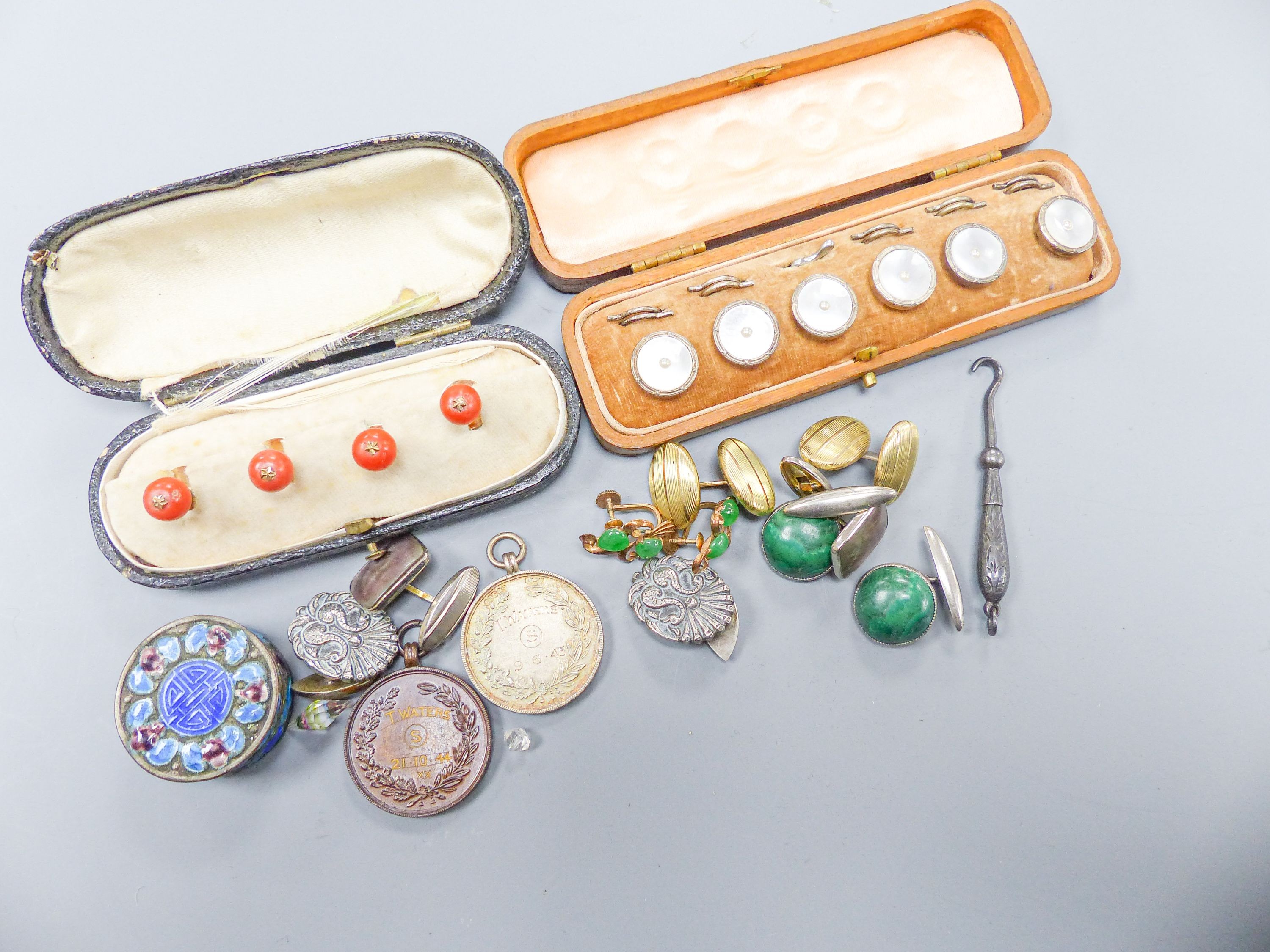 A set of four coral dress studs (cased), a set of six mother of pearl studs (cased), a pair of yellow metal cufflinks, a pair of silver cufflinks and sundry items